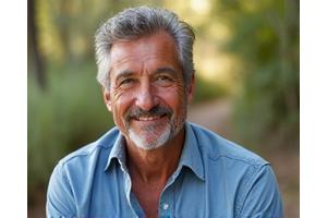 Foto de Miguel, hombre en sus 50s, sonriendo y en buena forma, simbolizando su éxito en el control del colesterol