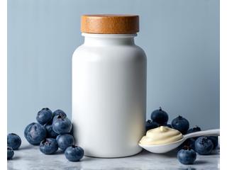 Envase de alta calidad de probióticos con tapa de madera, situado en una superficie de mármol con algunas frutas rojas y yogur alrededor, indicando un enfoque en la salud digestiva.